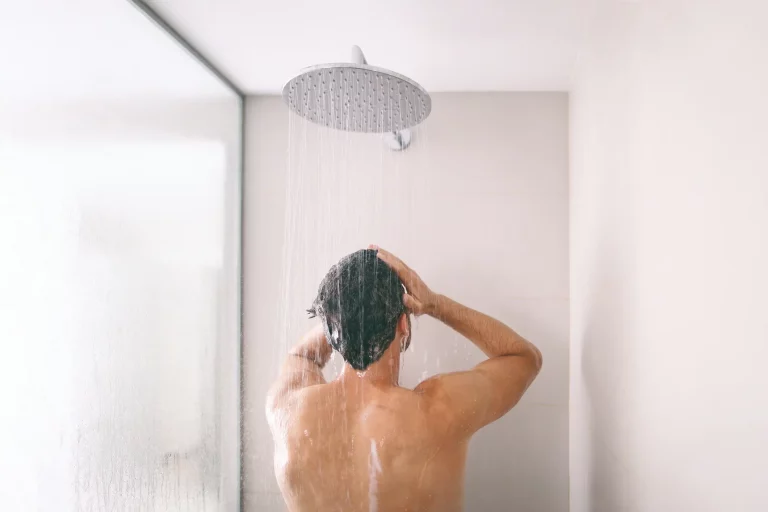 Mann duscht in einer fest installierten Regendusche