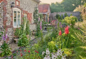 Englischer Landgarten, auch Cottage Garten genannt, im Sommer mit einem alten Backsteinhaus