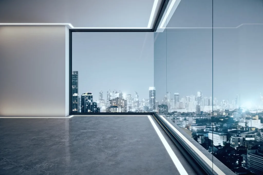 Bodenteifes Eckfenster in einem Büro mit Blick über eine beleuchtete Stadt