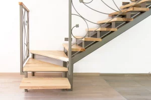 Viertelgewendelte Treppe in einer Wohnung mit Holzstufen und Treppengeländer aus Metall