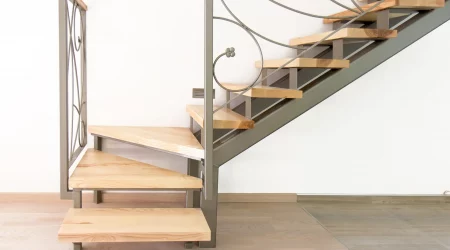 Viertelgewendelte Treppe in einer Wohnung mit Holzstufen und Treppengeländer aus Metall