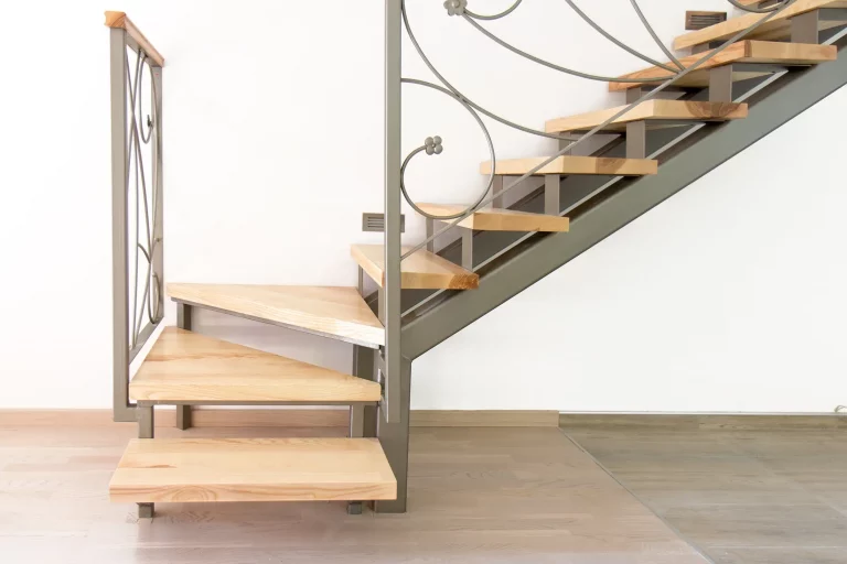 Viertelgewendelte Treppe in einer Wohnung mit Holzstufen und Treppengeländer aus Metall