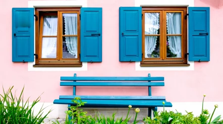 Holzfenster in einer rosa gestrichenen Hauswand