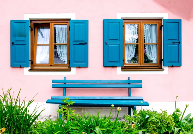 Holzfenster in einer rosa gestrichenen Hauswand
