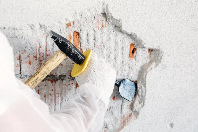 Putz wird mit Hammer und Meisel entfernt