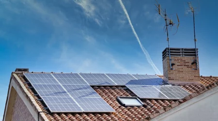 Solaranlage auf einem Dach eines Einfamilienhauses mit blauem Himmel im Hintergrund