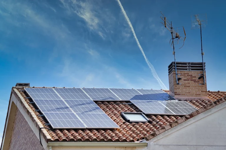 Solaranlage auf einem Dach eines Einfamilienhauses mit blauem Himmel im Hintergrund