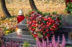 Gepflegtes Grab mit einem Blumengesteck und einer Kerze