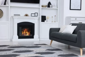 Stilvolles Wohnzimmer mit brennendem Kamin und grauem Sofa