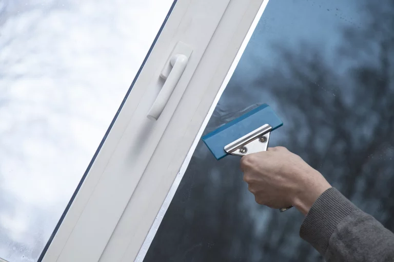 Installation von Fensterfolie im Büro. Schutz vor ultravioletter Strahlung.