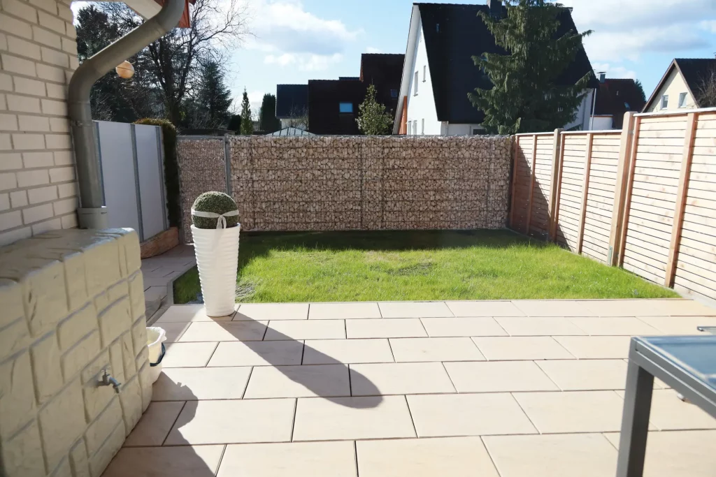 Ein Gabionenzaun die wie eine Mauer als Sichtschutz den Garten schützt