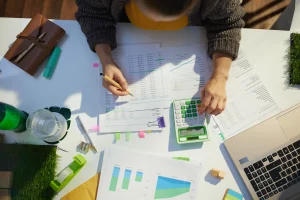 Steuerberaterin mit Taschenrechner und Dokumentenarbeit