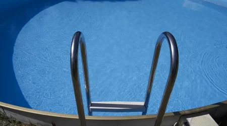Ein eingelassener Stahlwandpool mit Leiter in einem Garten