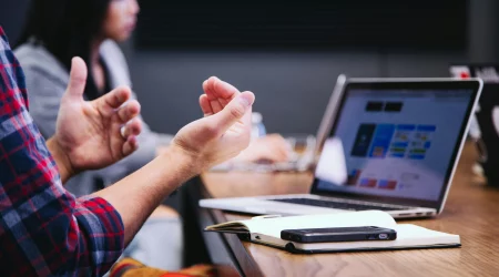 Person sitzt vor dem Laptop und berät über vermögenswirksame Leistungen