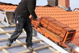 Dachdecker auf einem Dach mit Ziegeln bei einer Dacheindeckung