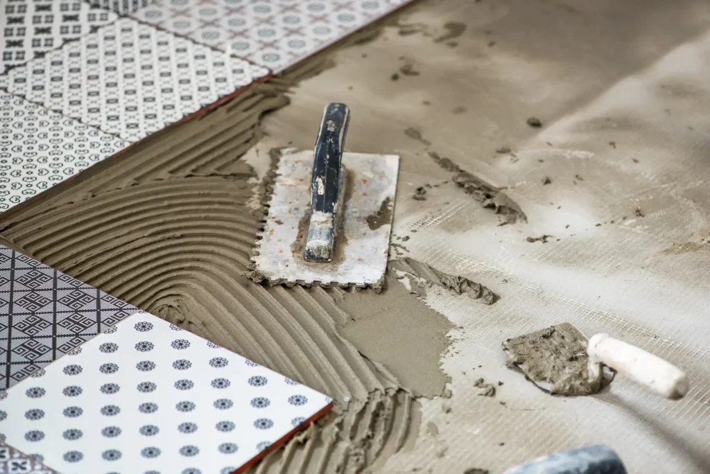 Dekotrative Fliesen mit Fliesenkleber und Spachtel