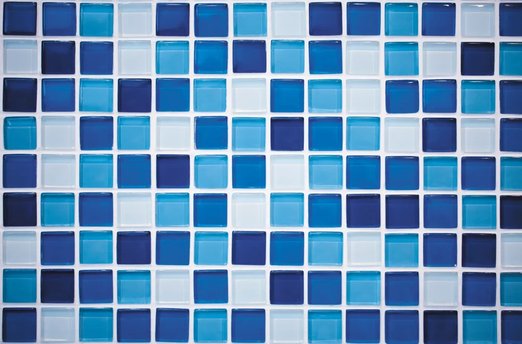 Ein Mosaik in einem Badezimmer aus Glasfliesen in unterschiedlichen Blautönen