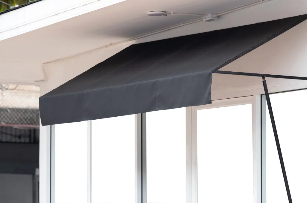 Schwarze Klemmmarkise auf einem kleinen Balkon