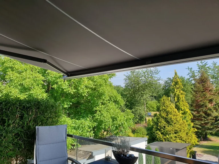 Neu bespannte Markise mit grau braunem Markisenstoff als Sonnenschutz auf einer Terrasse