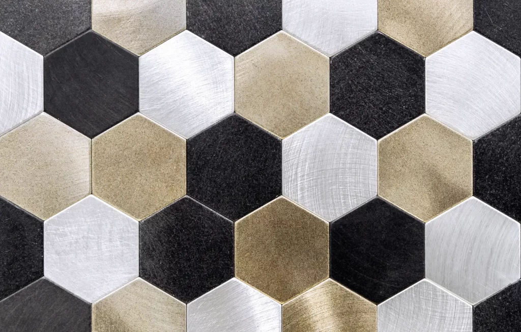 Metallfliesen in einem Mosaik mit goldenen, silbernen und schwarzen Metallfliesen