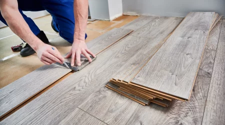 Laminatleger bei der Verlegung von Laminat in einem Zimmer