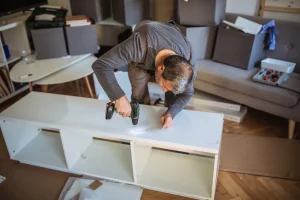 Möbelmonteur baut ein Regal in einer Wohnung auf