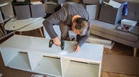 Möbelmonteur baut ein Regal in einer Wohnung auf