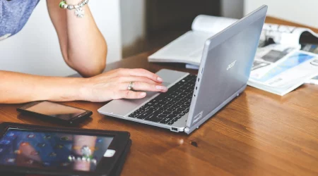 Frau sitzt am Laptop und prüft über Onlinebanking ihre Finanzen