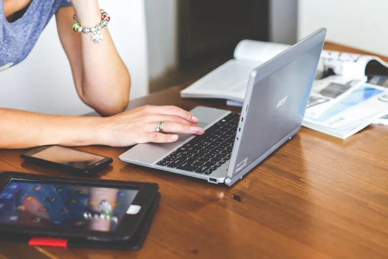 Frau sitzt am Laptop und prüft über Onlinebanking ihre Finanzen