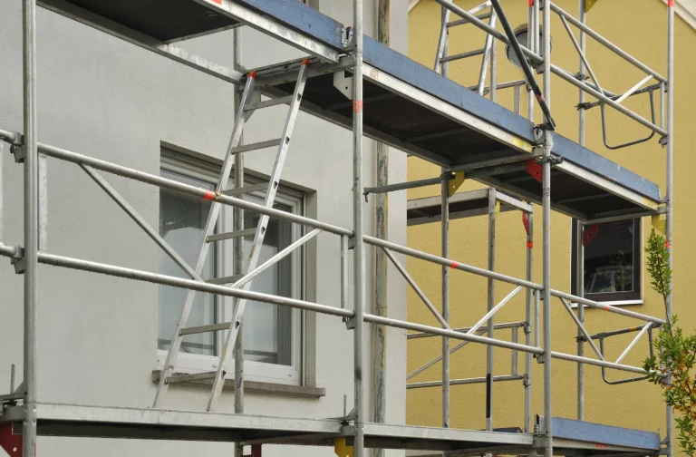 Metallgerüst mit Leitern an der Fassade eines zu renovierenden Gebäudes