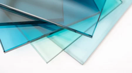 Mehrere leicht gestapelte, blaue und transparente Scheiben aus Einscheibensicherheitsglas (ESG) auf einem weißen Hintergrund. Das Bild zeigt die klare und robuste Beschaffenheit des Glases, das häufig für Türen, Fenster und Trennwände verwendet wird.
