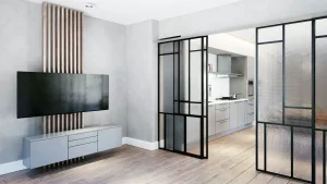 Modernes Wohnzimmer mit maßgefertigten Glastüren, die Küche und Wohnbereich trennen. Die Glastüren haben schwarze Metallrahmen und geriffelte Glasflächen. Der Raum ist minimalistisch gestaltet mit einem großen Flachbildfernseher an einer Akzentwand und einem eleganten, schwebenden Sideboard. Heller Holzboden und dezente Beleuchtung sorgen für eine einladende Atmosphäre.