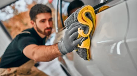 Mann poliert Auto mit einem Tuch