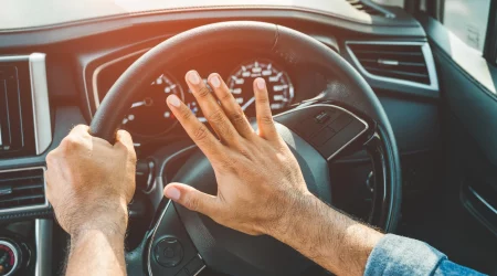 weibliche Hand hupt im Auto