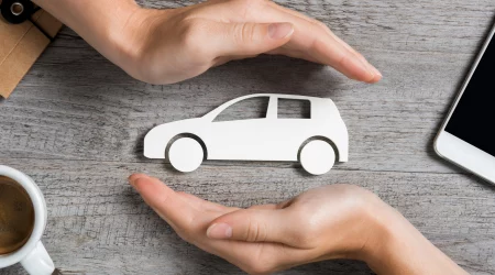 schützend die Hände um ein Auto halten