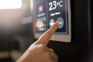 Ein Finger berührt ein elektrisches Thermometer, um die Temperatur einzustellen.