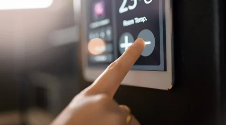 Ein Finger berührt ein elektrisches Thermometer, um die Temperatur einzustellen.