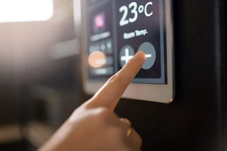 Ein Finger berührt ein elektrisches Thermometer, um die Temperatur einzustellen.