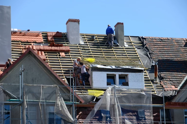 Dachdecker decken ein Dach eines Wohnreihenhauses
