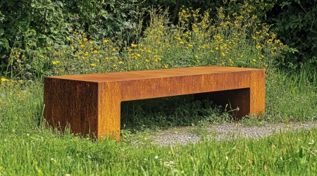 Eine Sitzbank in einem Garten aus Cortenstahl