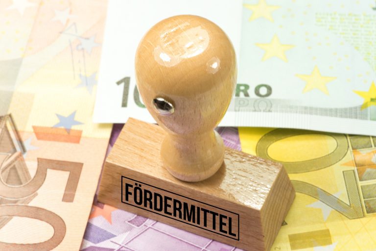 Euroscheine auf denen ein Stempel liegt, auf dem steht "Fördermittel".