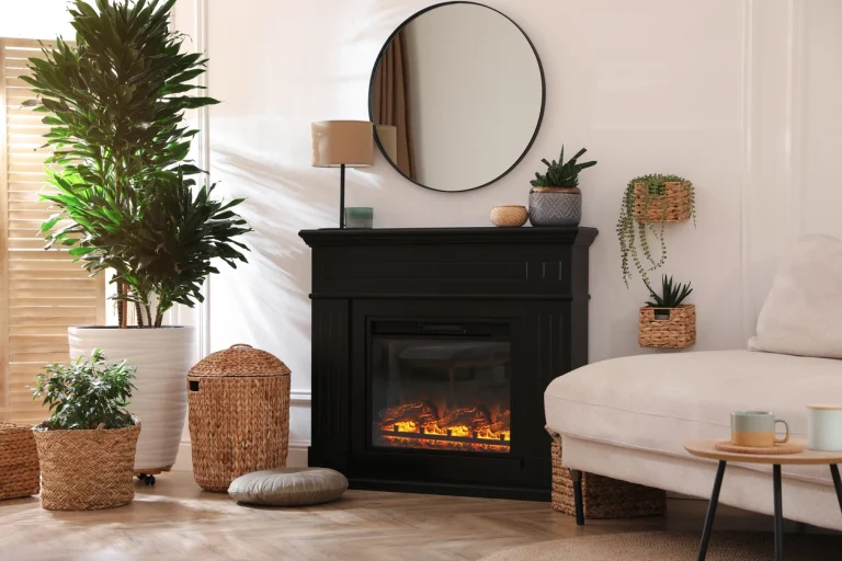Kamin in der Mitte eines hellen Wohnzimmers. Daneben stehen eine Pflanze und ein weißes Sofa.