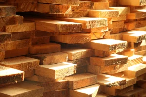 Verschieden lange Holzbretter liegen aufeinander aufgeschichtet.