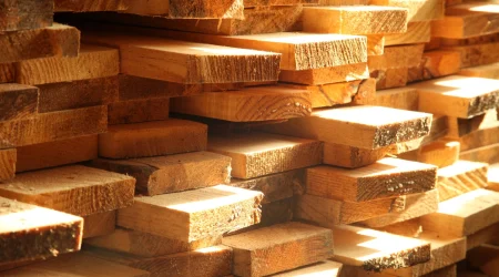 Verschieden lange Holzbretter liegen aufeinander aufgeschichtet.