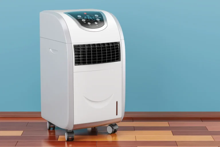 Mobile Klimaanlage mit Digitalanzeige und Bedienfeld, auf Rollen stehend, vor einer blauen Wand und einem Holzboden platziert. Das Gerät verfügt über Lüftungsgitter an der Vorderseite und ein modernes Design.