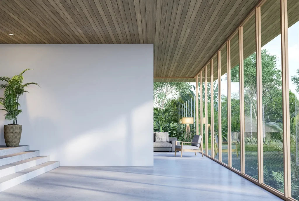 Modernes, lichtdurchflutetes Interieur einer Luxuswohnung mit großen Panoramafenstern und poliertem Anhydritestrich als Sichtestrich. Minimalistisches Design mit Holzdecke, einer grünen Pflanze in einem Korb und stilvollen Möbeln, die eine Verbindung zur natürlichen Außenumgebung schaffen.