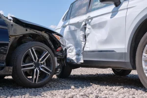 Ein helles und ein dunkles Auto sind in einen Unfall verwickelt und sind seitlich und frontal betroffen.