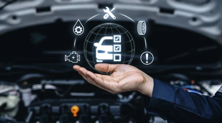 Eine Hand hält eine schwebende Grafik in der Luft. Im Hintergrund ist eine geöffnete Motorhaube zu sehen.