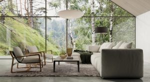Alt-Text: Moderner Wohnbereich mit bodentiefen Glaswänden, die einen Panoramablick auf eine grüne Waldlandschaft bieten. Der Raum ist mit einer grauen Couch, zwei eleganten Sesseln aus Holz, einem flauschigen Teppich und einem minimalistischen Couchtisch ausgestattet. Eine Hängelampe und ein Stehlampen-Design ergänzen das stilvolle Ambiente.