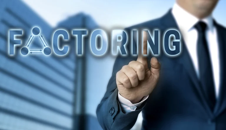 Ein Geschäftsmann in Anzug und Krawatte steht vor einem modernen Bürogebäude. Er zeigt mit seinem Finger auf das Wort ‚Factoring‘, das in großen, leuchtenden Buchstaben auf dem Bild dargestellt ist.